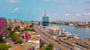Vue aérienne de Lagos, Nigeria, montrant des gratte-ciels, des routes animées et la lagune.